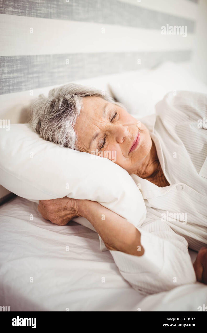 Senior woman sleeping on bed Stock Photo