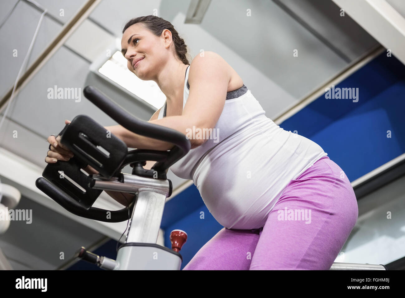 Pregnant woman using exercise bike Stock Photo Alamy