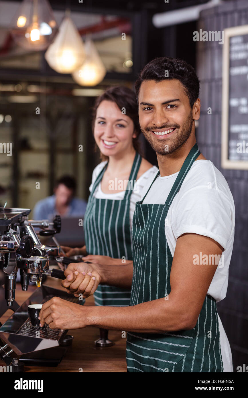 Smiling baristas using coffee machine Stock Photo Alamy