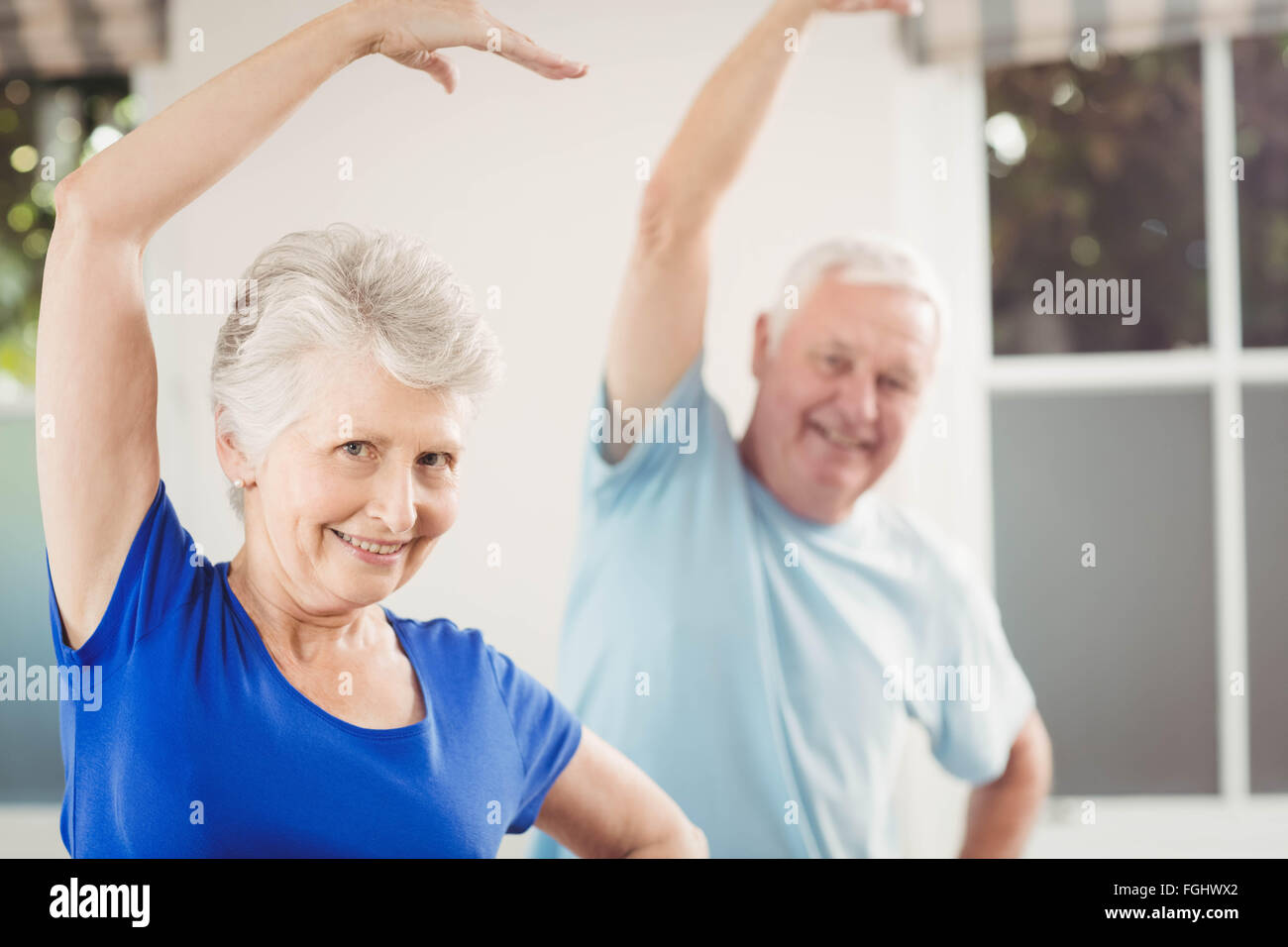 Portrait of senior couple performing stretching exercise Stock Photo ...