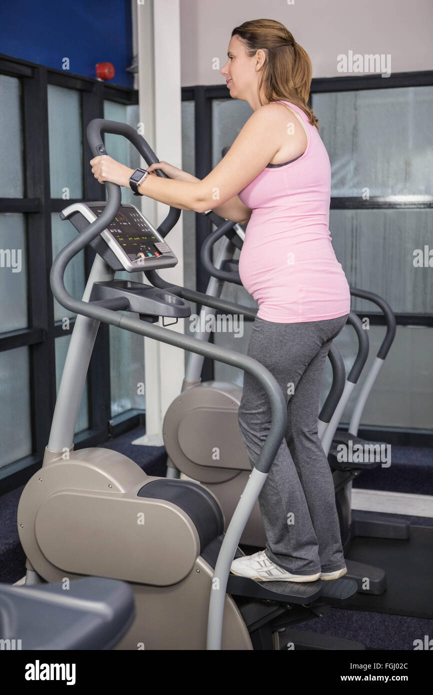 Pregnant woman on crosstrainer Stock Photo Alamy