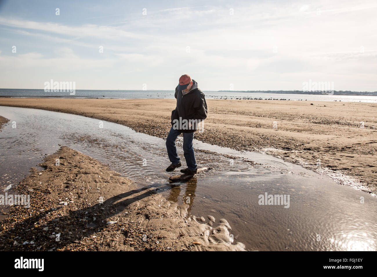 Man jumping creek outlet in South Amboy, NJ Stock Photo - Alamy