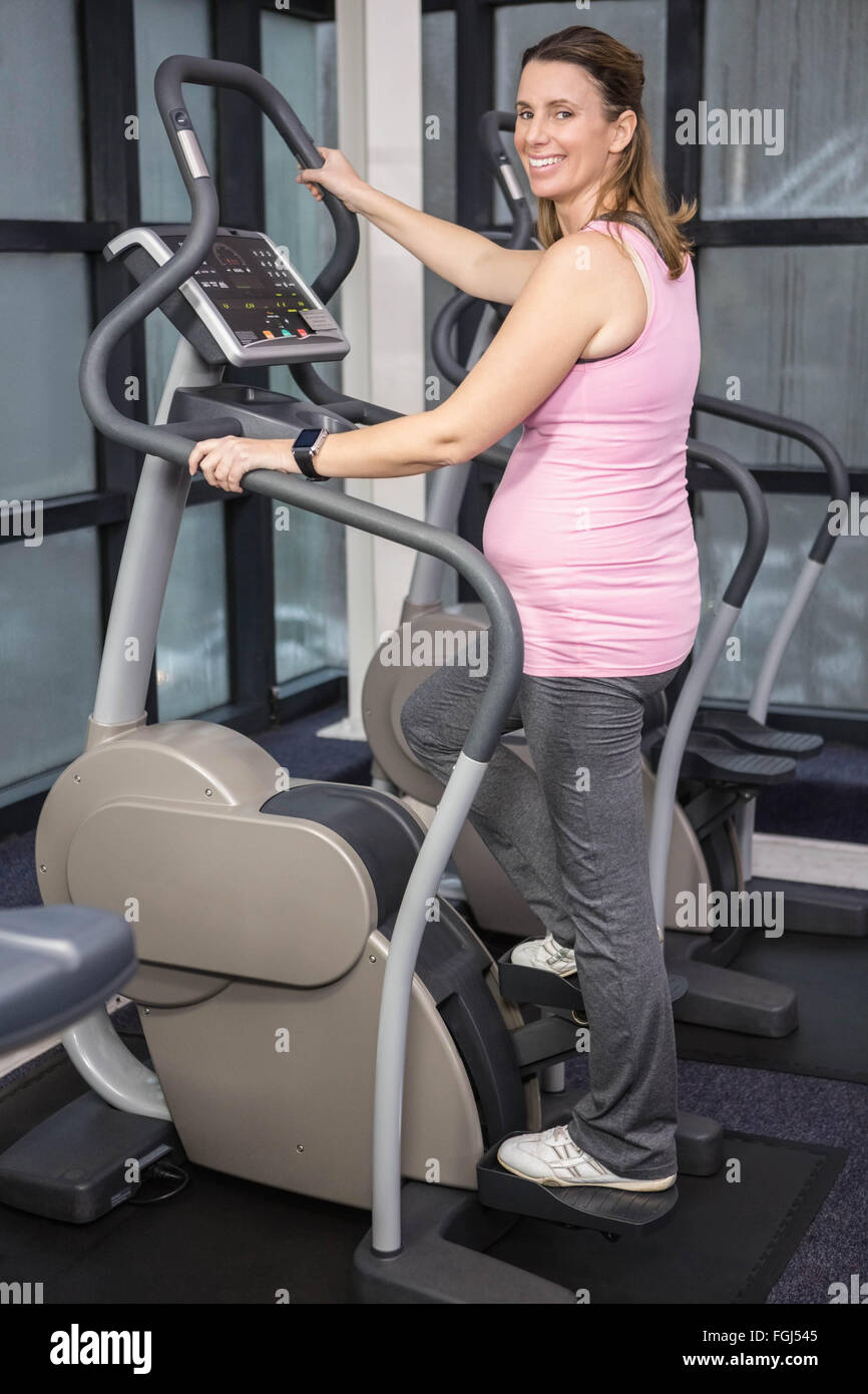 Pregnant woman on crosstrainer Stock Photo Alamy
