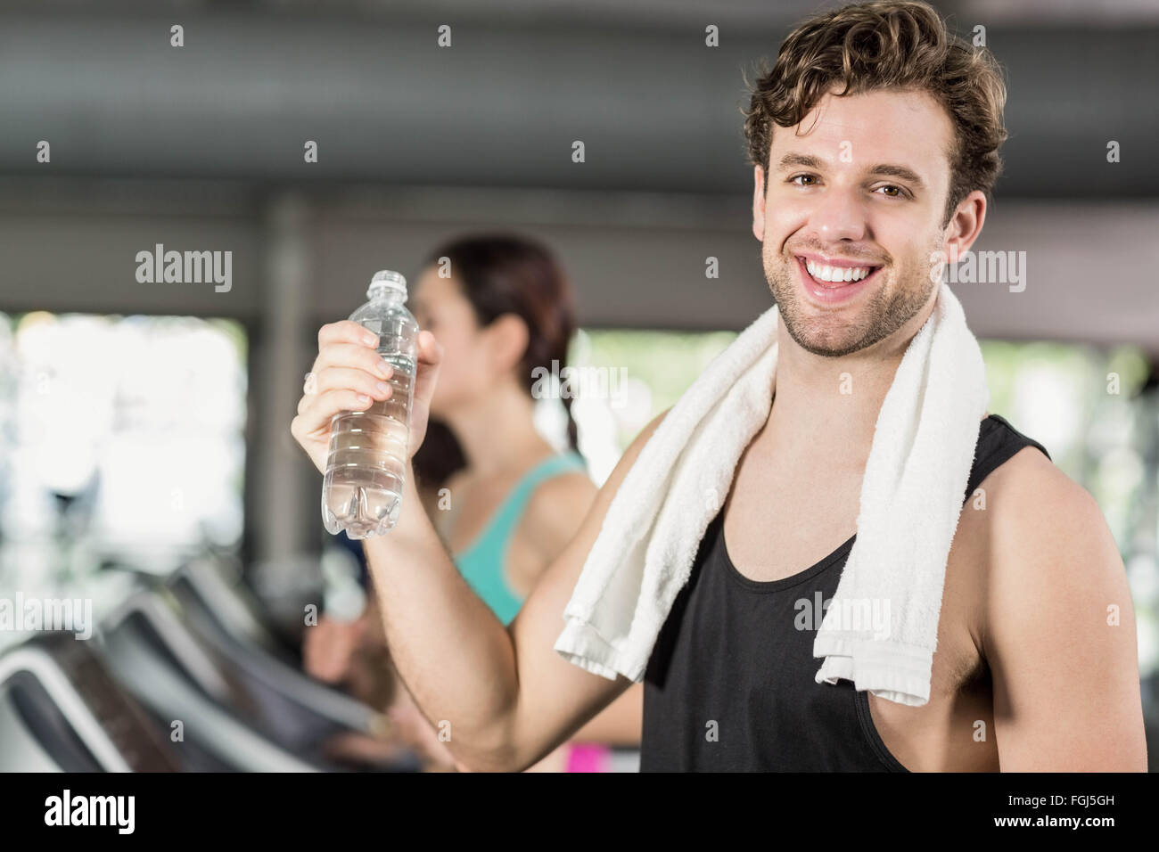Athletic man drinking water while running on treadmill Stock Photo Alamy