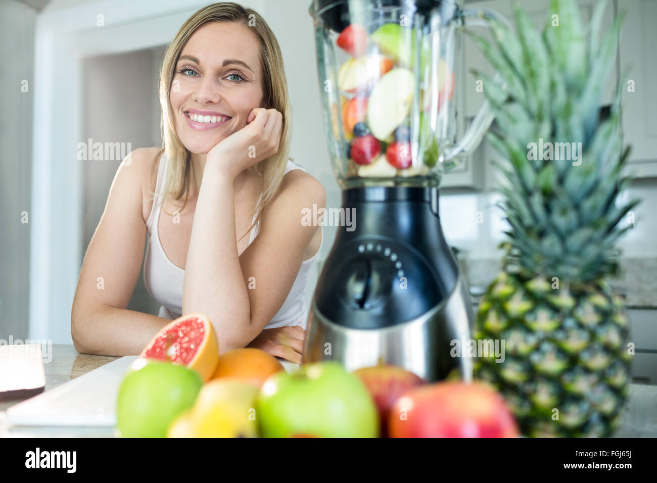 Pretty blonde woman happy to prepare a smoothie Stock Photo