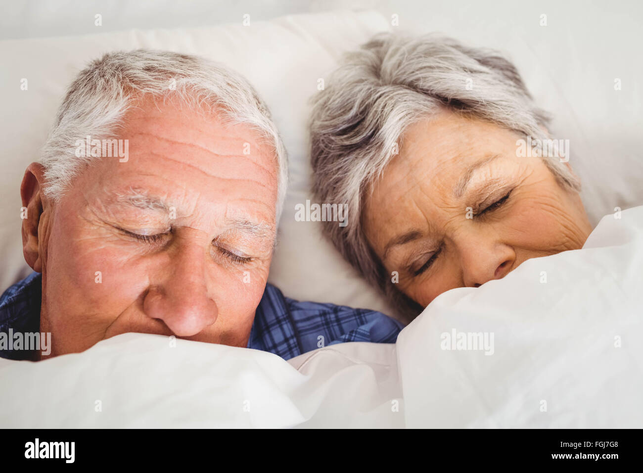 Senior couple sleeping on bed Stock Photo