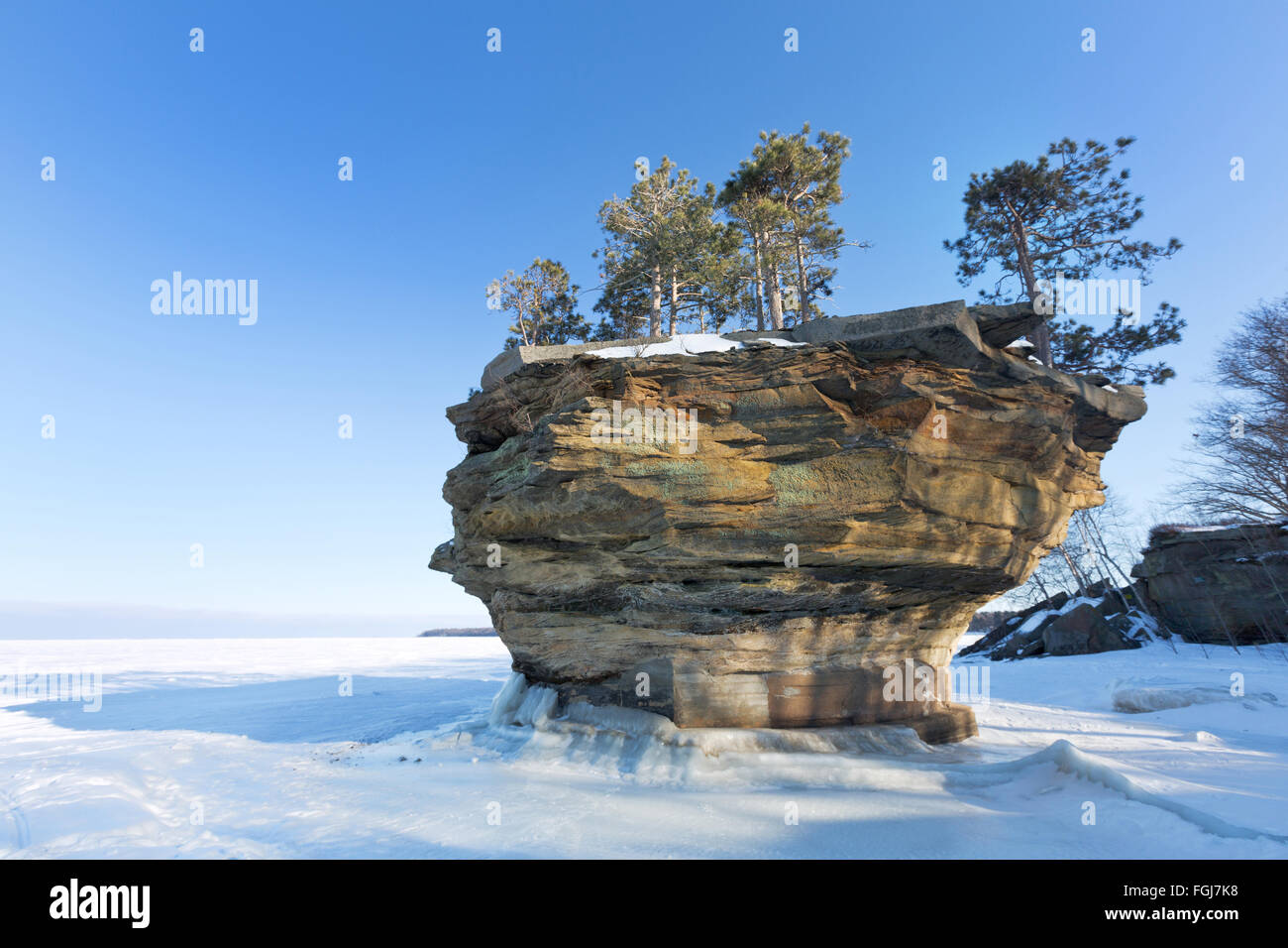 This sea stack of rock, known as Turnip Rock, rises from the ice of a frozen Lake Huron in winter. Port Austin Michigan Stock Photo