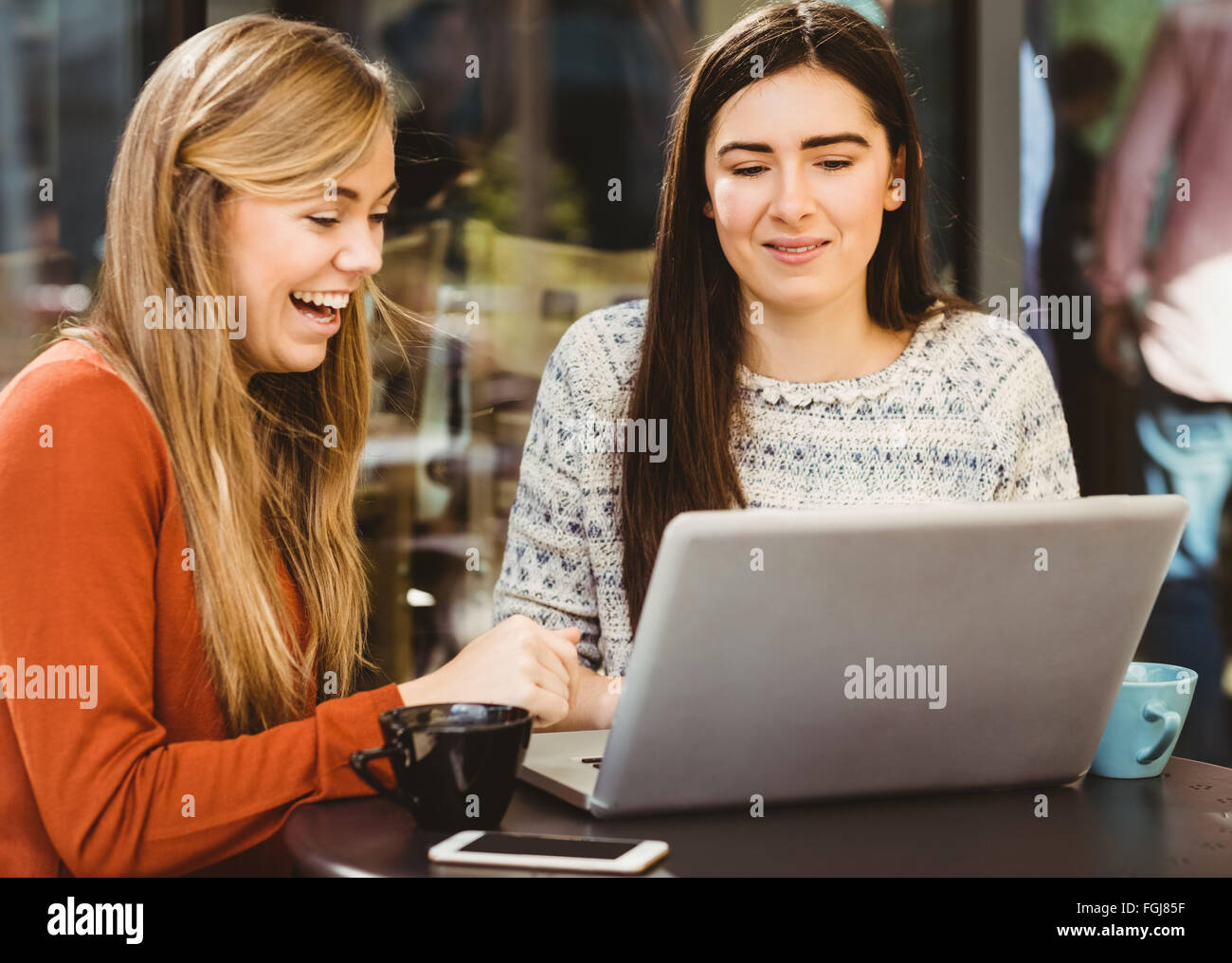 Friends using laptop together Stock Photo - Alamy