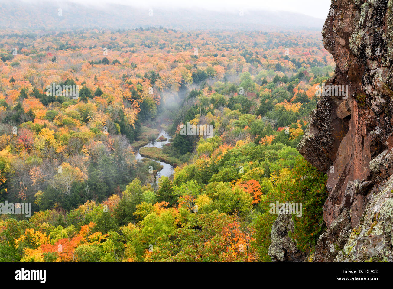 Porcupine Mountains Carp River Valley. Autumn colors pop with saturation from the mist as fog drifts above the river. Stock Photo