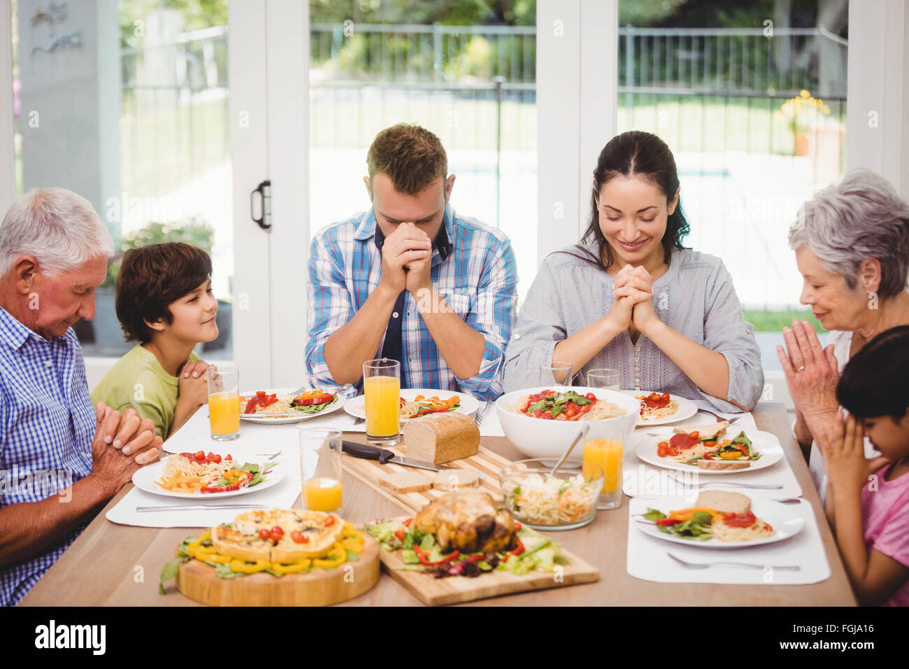 Family praying together before meal Stock Photo Alamy