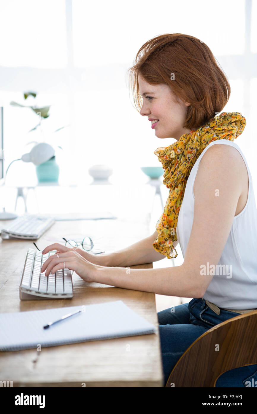 smiling hipster businesswoman typing on her computer Stock Photo