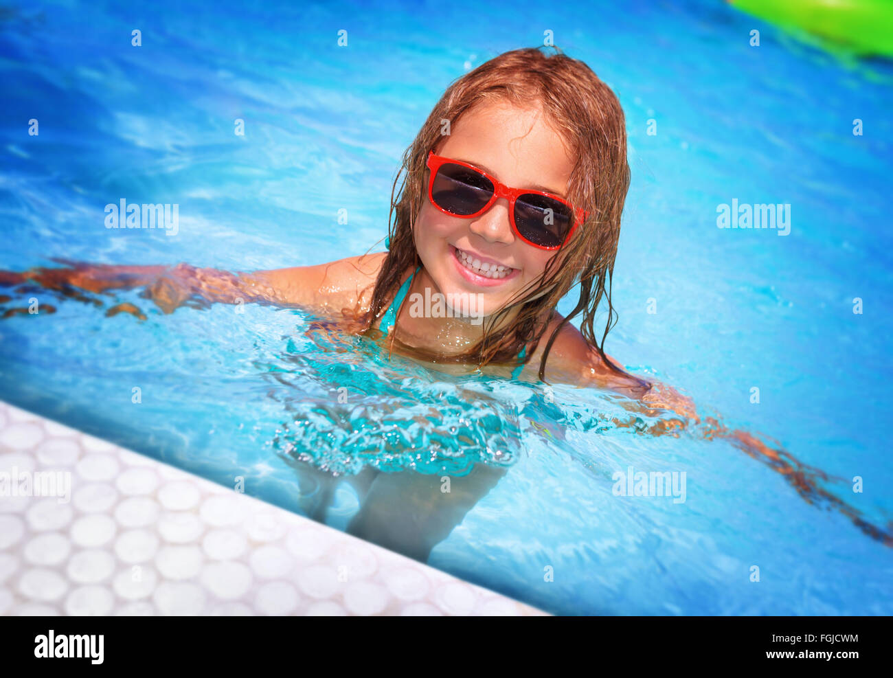 Portrait of cute happy little girl having fun in swimming pool, adorable baby spending summer vacation on the beach resort Stock Photo