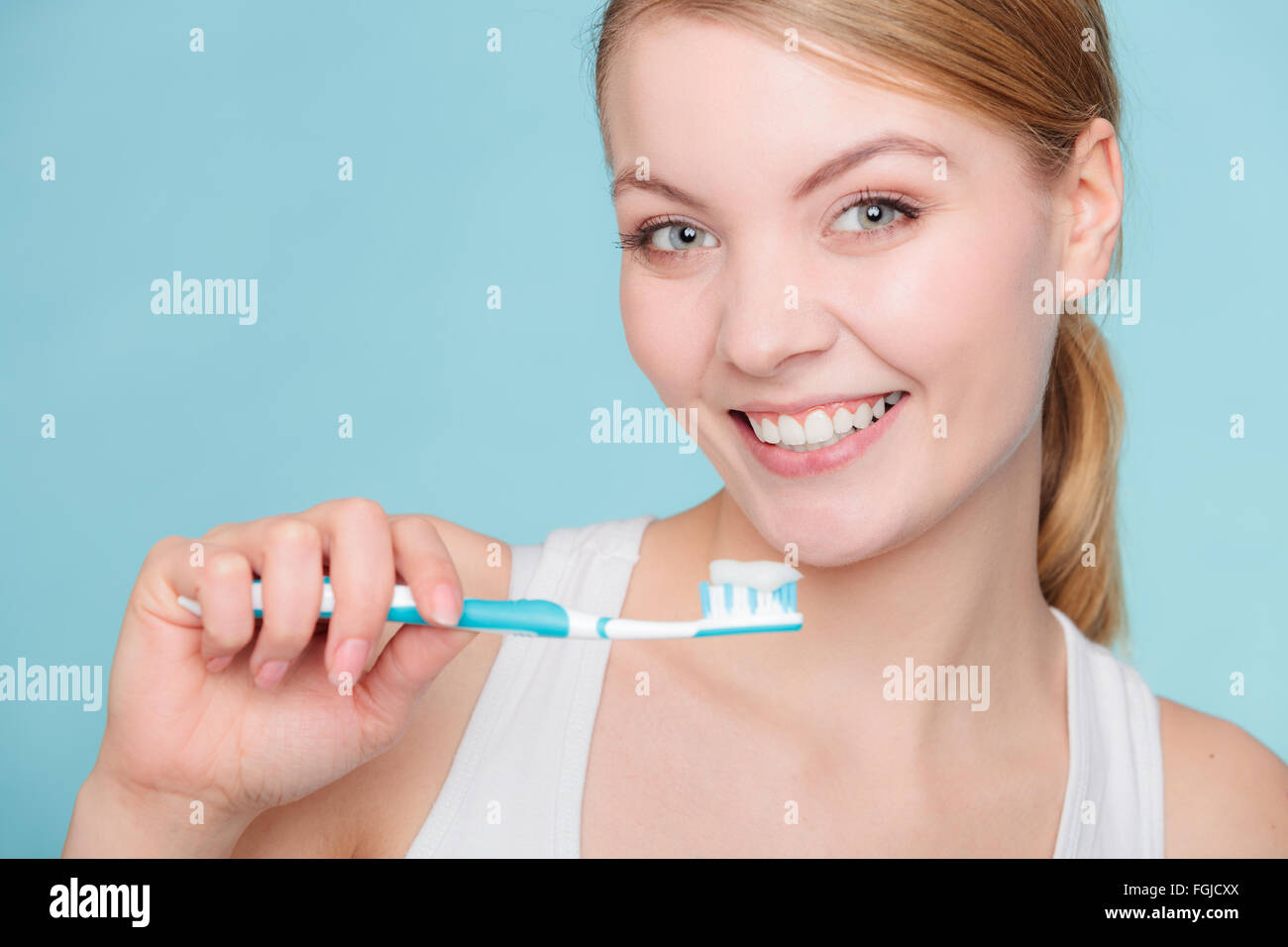 Young woman brushing cleaning teeth. Girl holds toothbrush with
