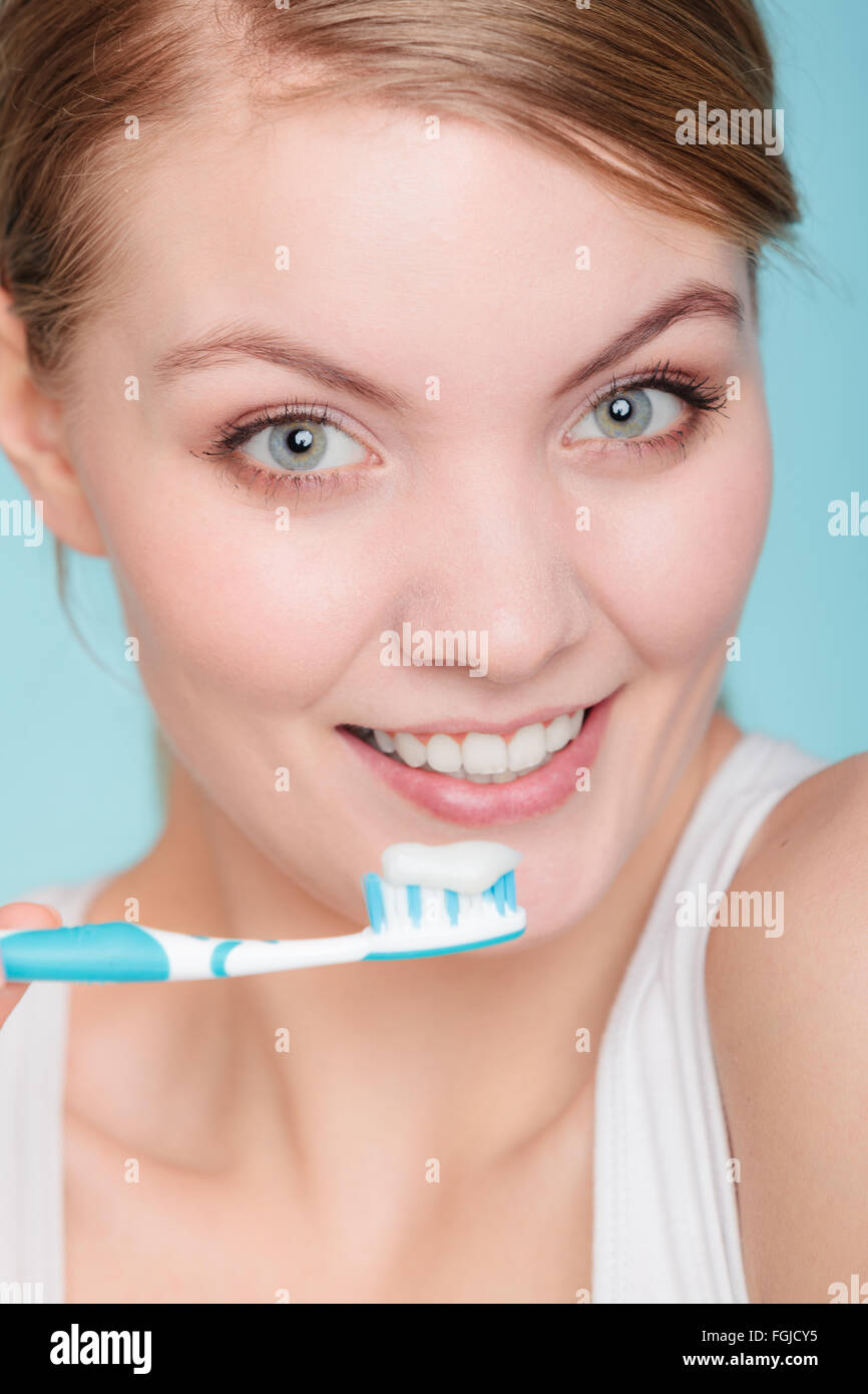 Young woman brushing cleaning teeth. Girl holds toothbrush with