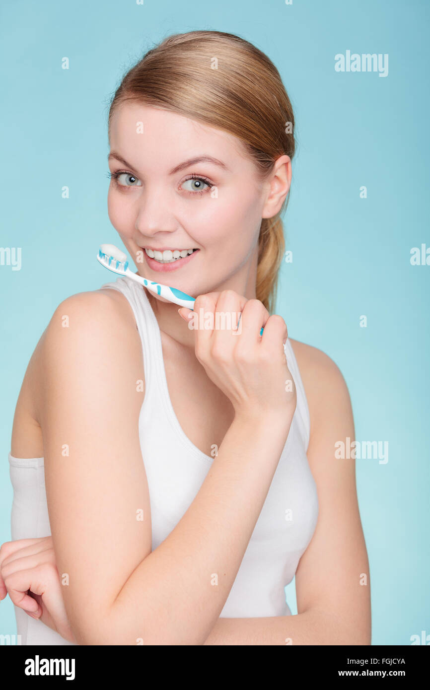 Young woman brushing cleaning teeth. Girl holds toothbrush with