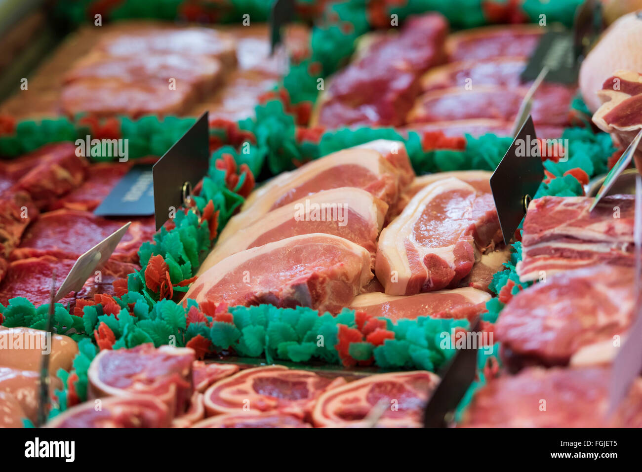 Red meat on display in a butcher's shop window. Stock Photo