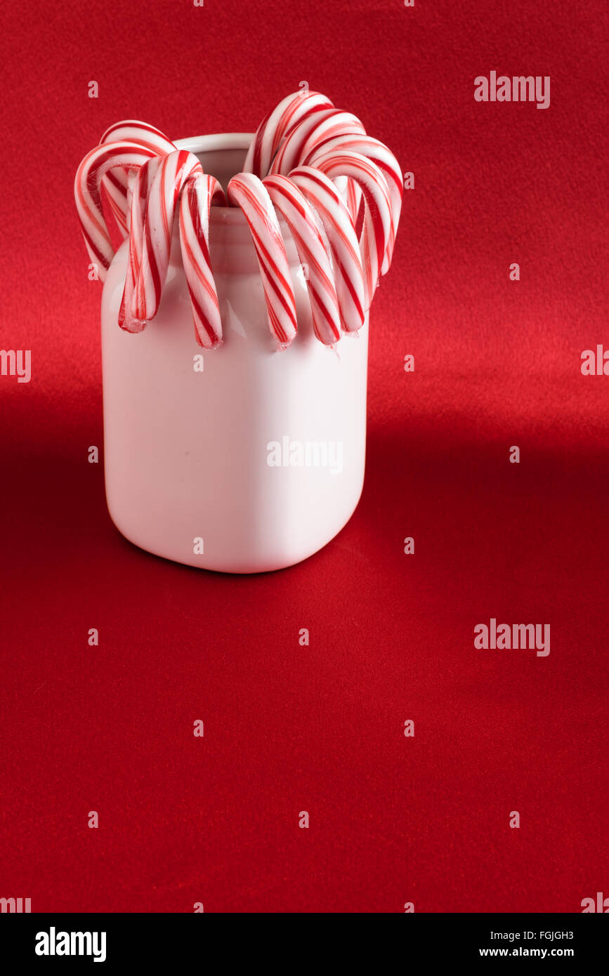 Candy canes in a white ceramic jar on a red background Stock Photo Alamy
