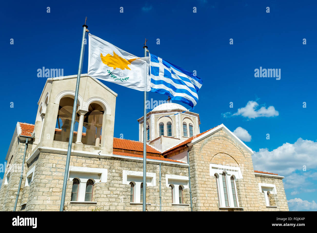 Waving flag of Cyprus and Greece with Orthodox church on the background. Dora Village, Limassol District, Cyprus Stock Photo