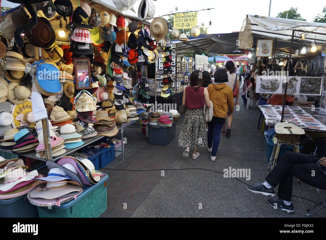 hat stall and tourists at the Sunday night market Tha Pae walking street in Chiang Mai Thailand Stock Photo