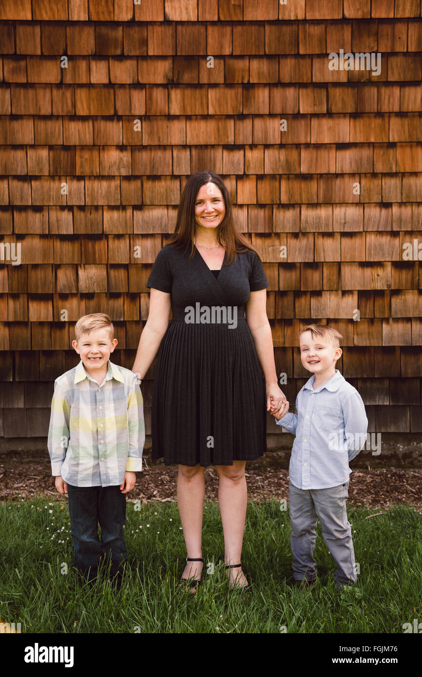 Mom with two kids, both boys, in a lifestyle portrait outdoors. Stock Photo