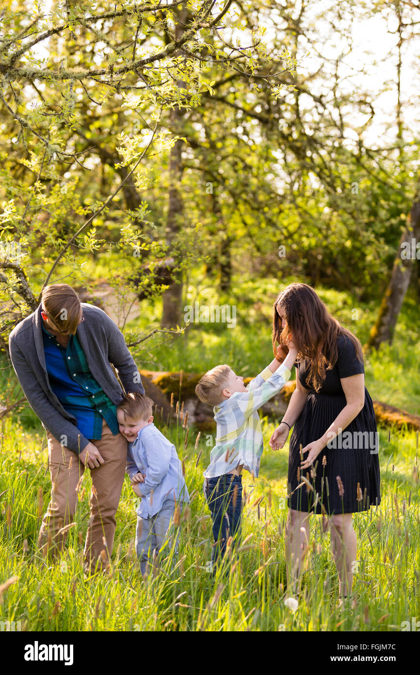 Family of four outdoors in a natural setting with nice light in a lifestyle portrait. Stock Photo