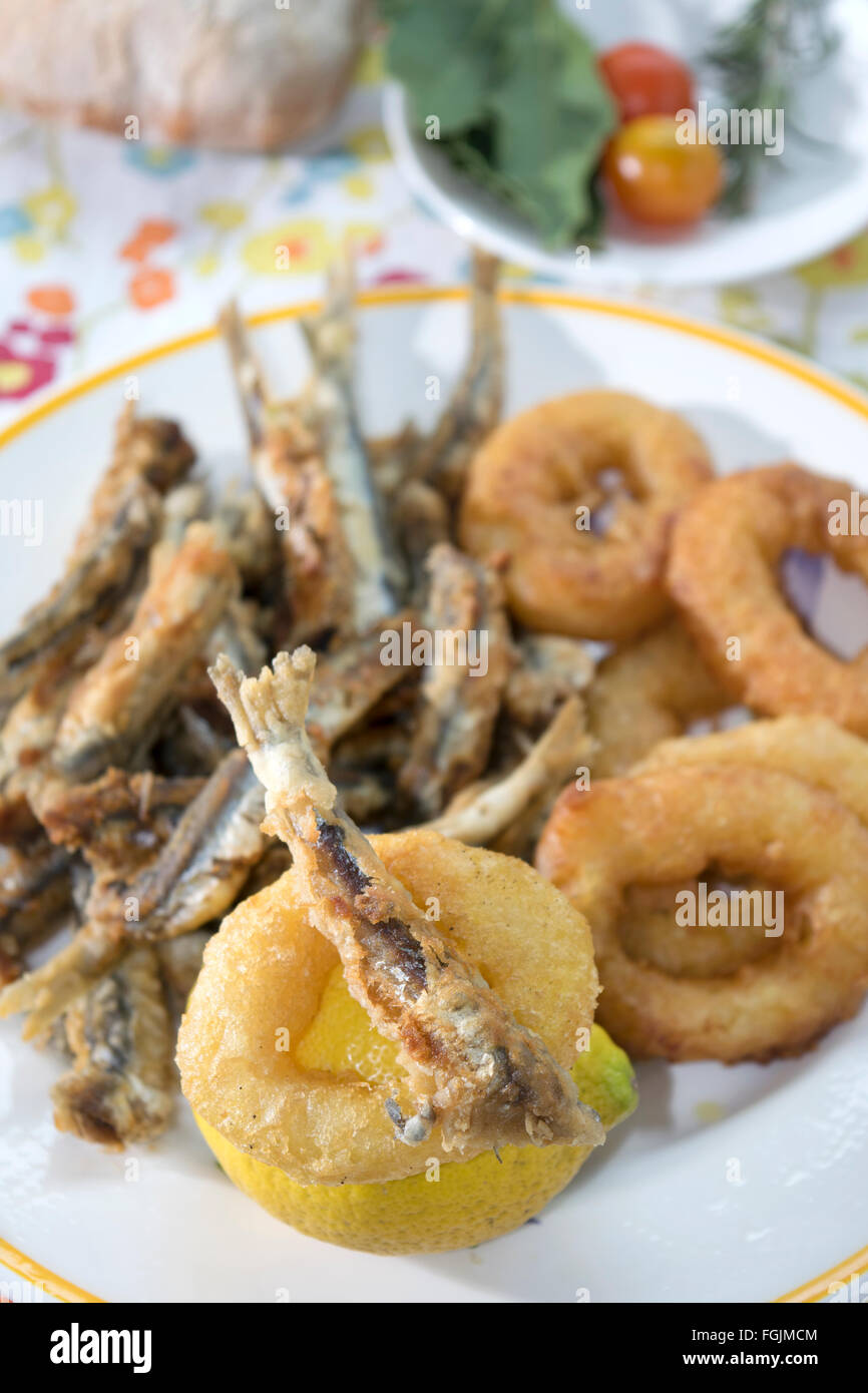 battered and fried rings of squid anchovy fillets Stock Photo - Alamy