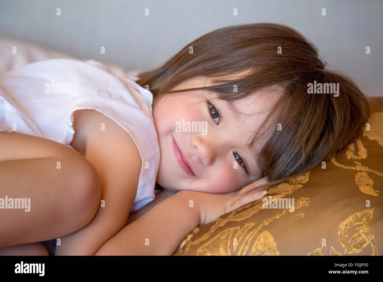 Three year old girl resting on the bed Stock Photo