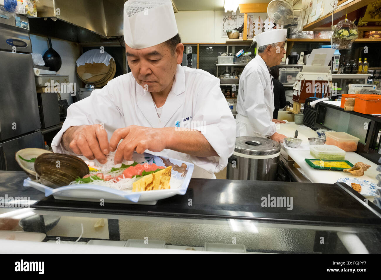 Chefs prepare a meal at a Sushi-bar in Miyagi, Japan. The original restaurant was destroyed during the 2011 earthquake, tsunami. Stock Photo