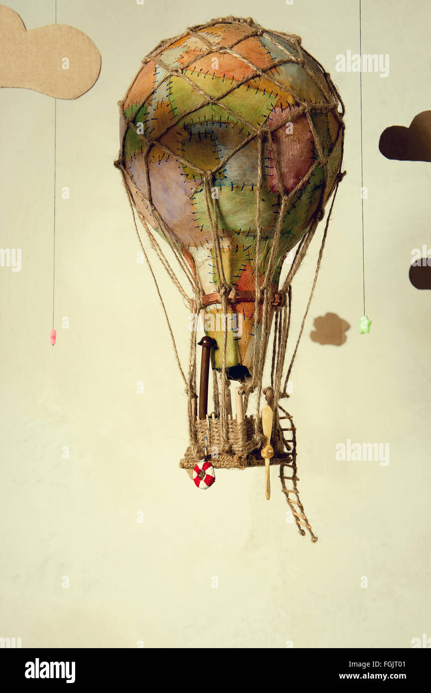 Strange steampunk balloon which flies between clouds and aims for the stars. On light background Stock Photo