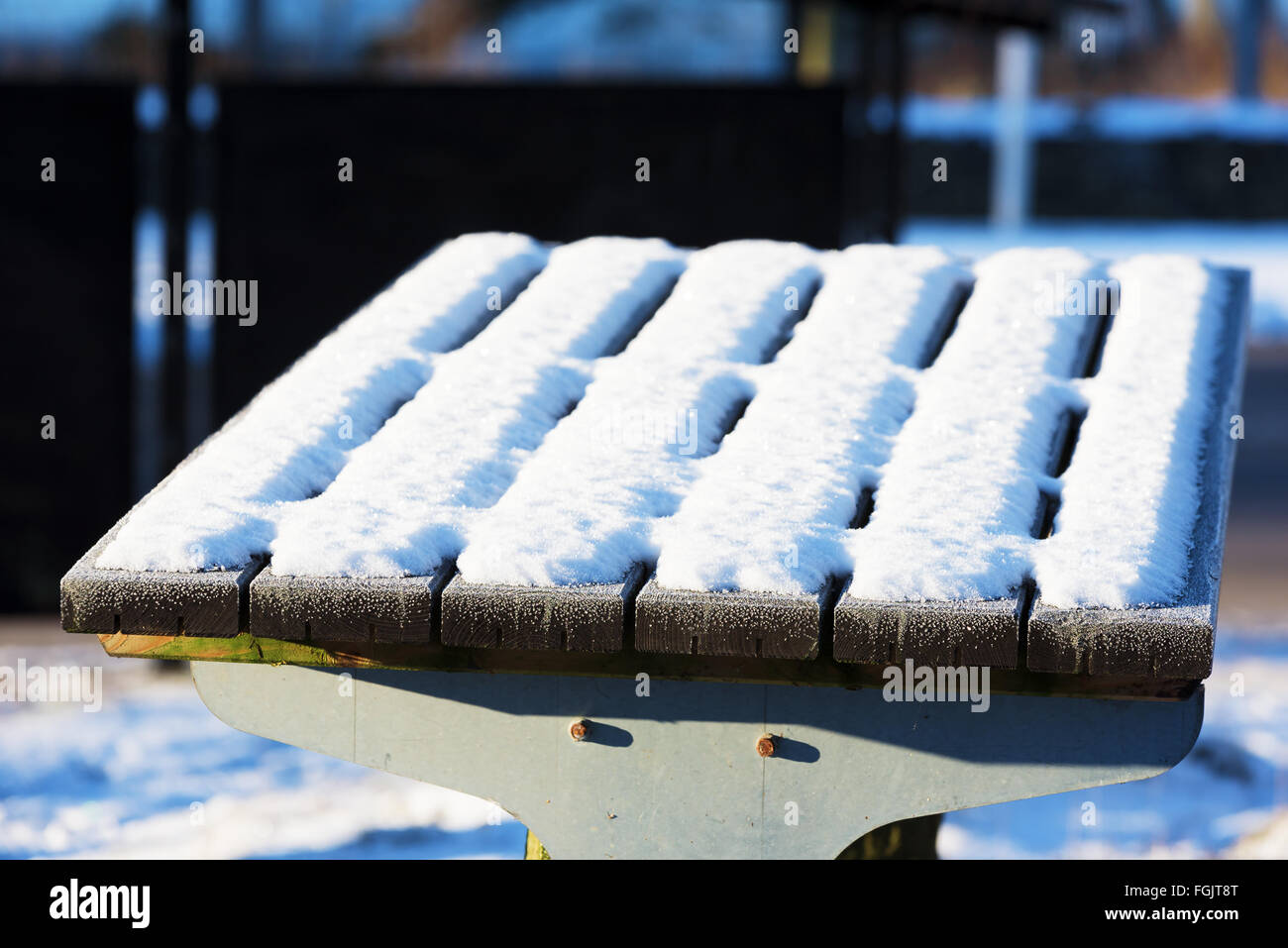 An outdoor tabletop covered with snow and frost in winter. Stock Photo