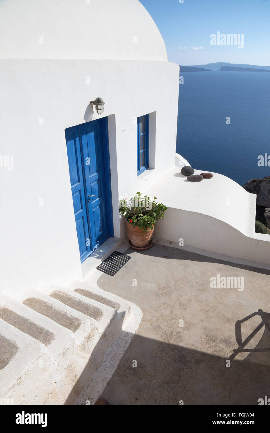Santorini - The look to typically house ower the caldera wiht the white stairs and blue dors in Oia. Stock Photo