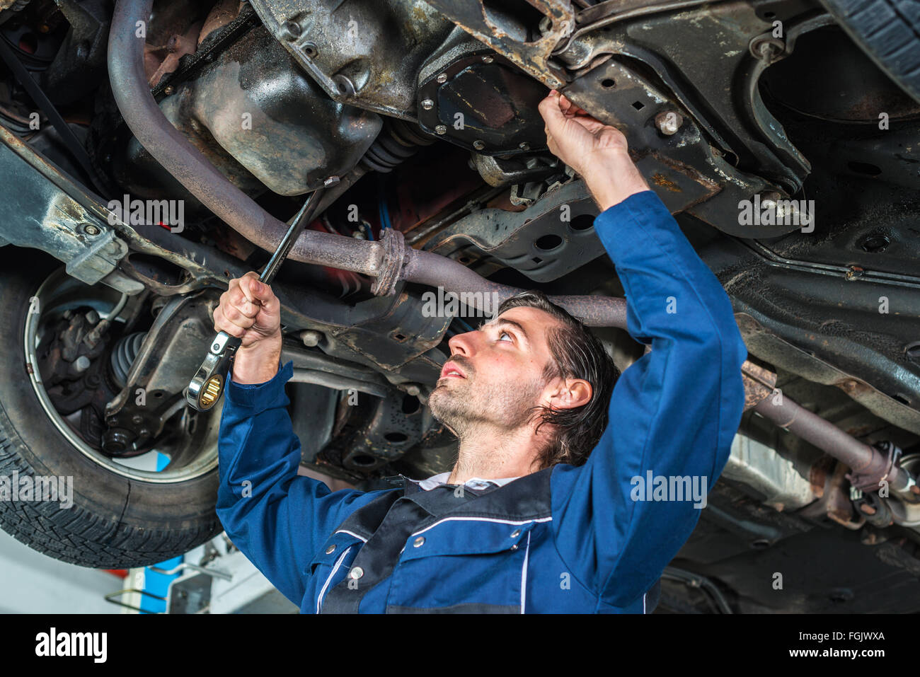 Mechanic checking the condition of a lifted car Stock Photo Alamy