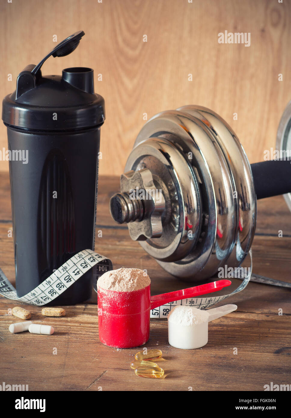 https://c8.alamy.com/comp/FGK06N/whey-protein-powder-in-scoop-with-vitamins-and-plastic-shaker-on-wooden-FGK06N.jpg