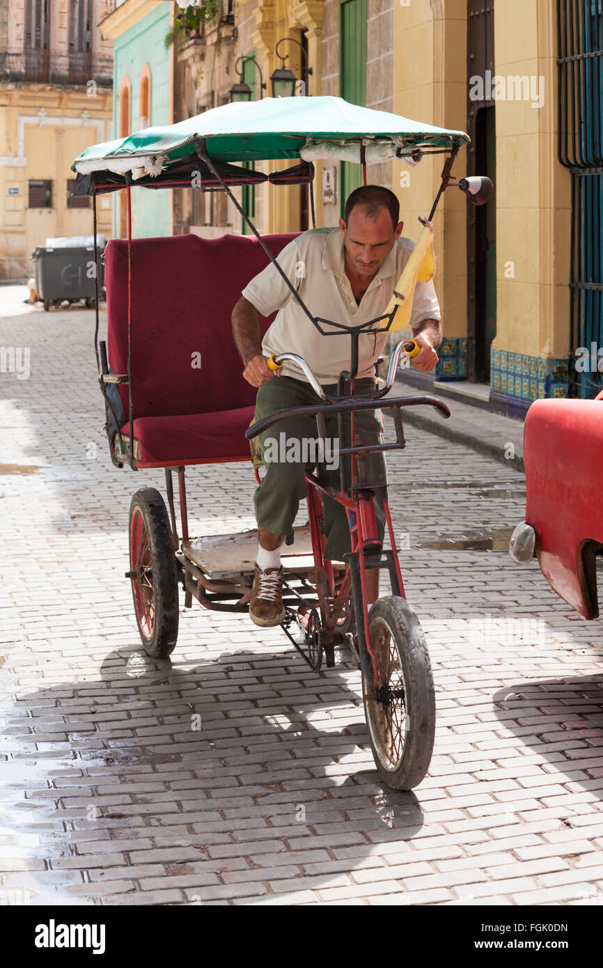 Daily life in Cuba - Local man riding bicitaxi bicycle taxi at Havana, Cuba, West Indies, Caribbean, Central America Stock Photo