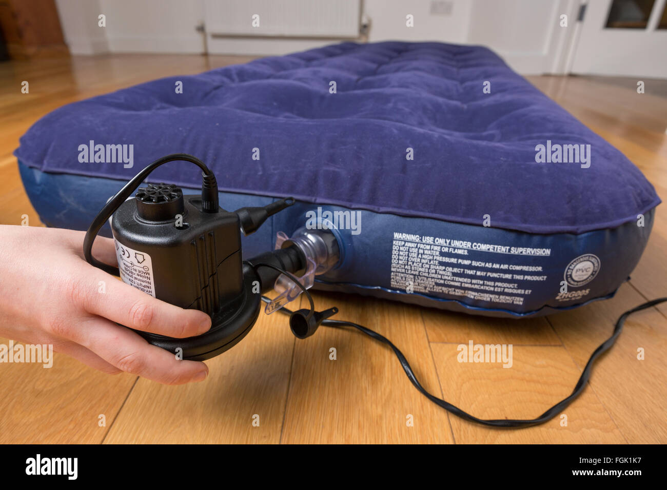 An air bed being inflated with an electric pump Stock Photo