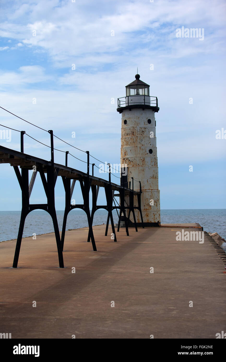 The Manistee lighthouse sits at the end of the pier and the catwalk surrounded by Lake Michigan Stock Photo