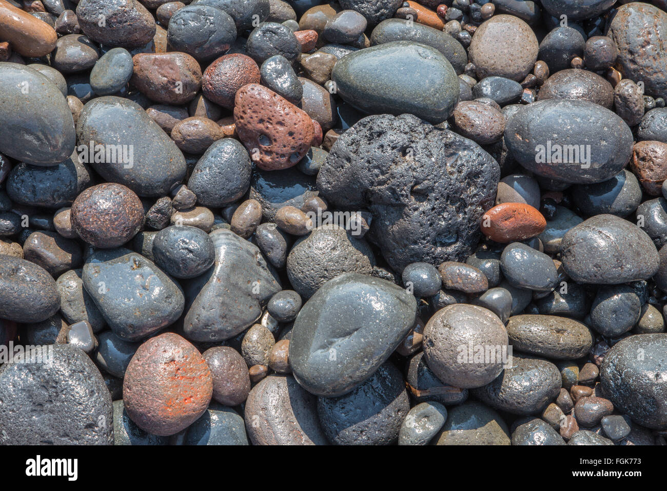 Santorini - The detail of pemza from Black beach in the wave . Stock Photo