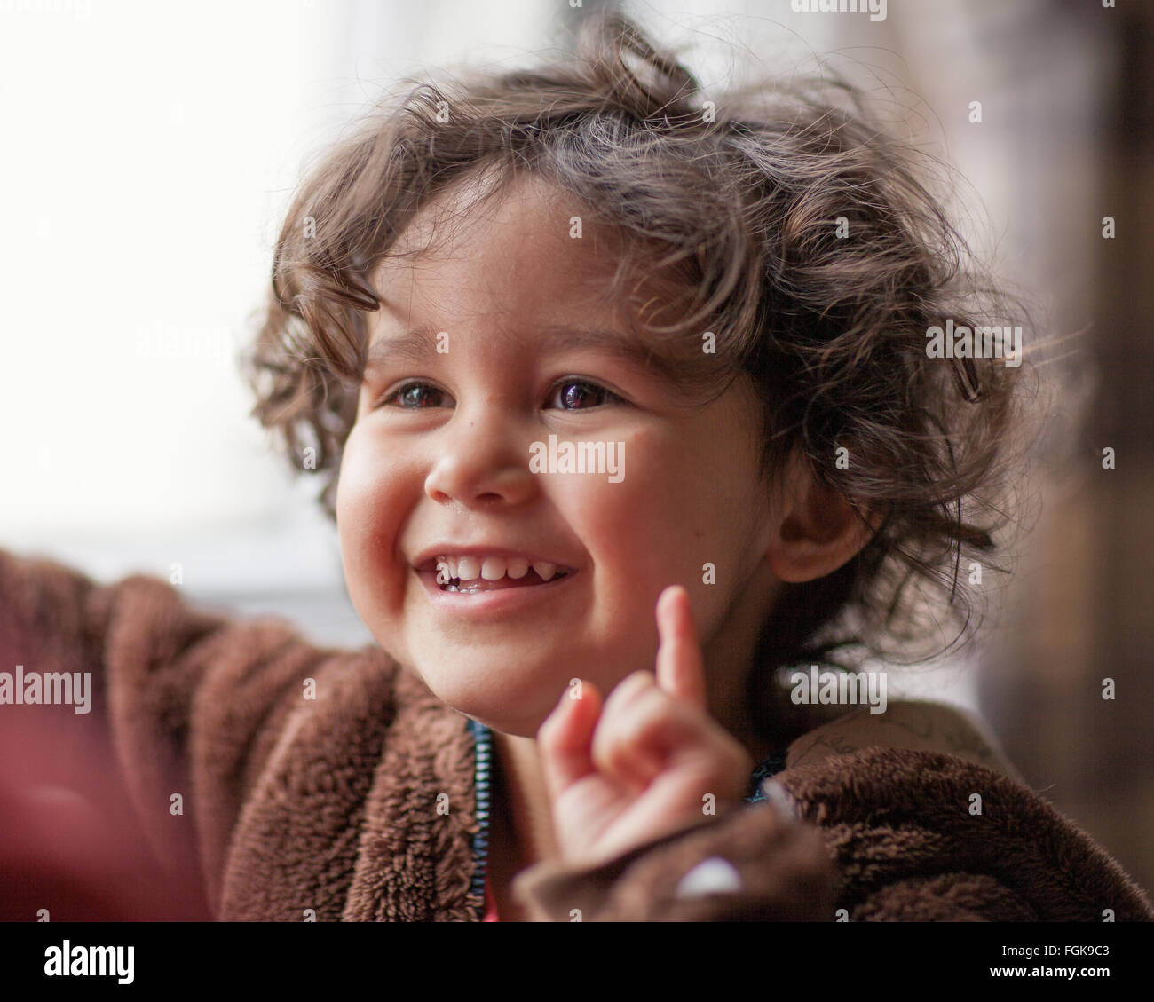 Mixed race three year old boy pointing or signaling,one. Stock Photo