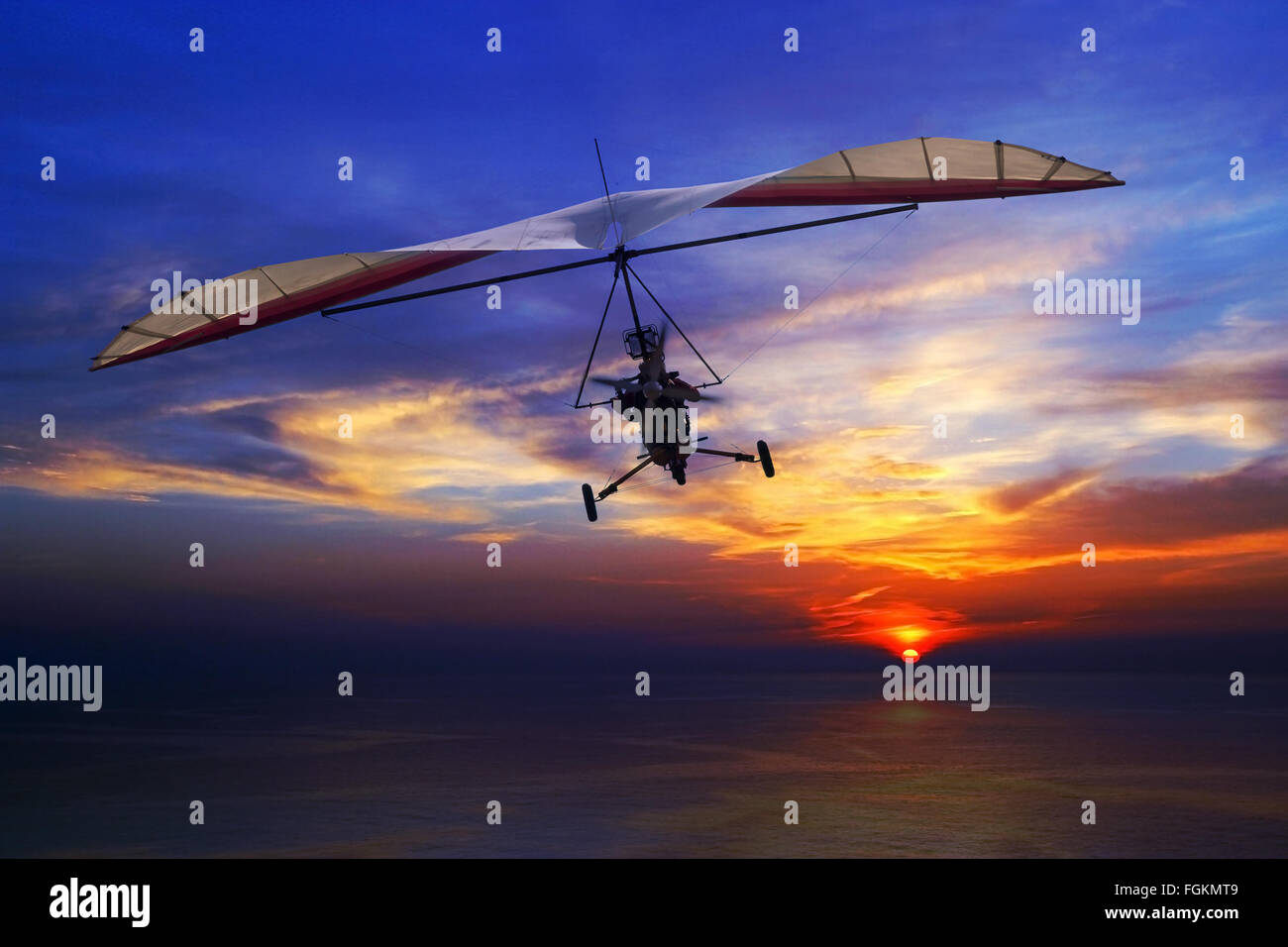 The motorized hang glider in the sunset above sea Stock Photo Alamy