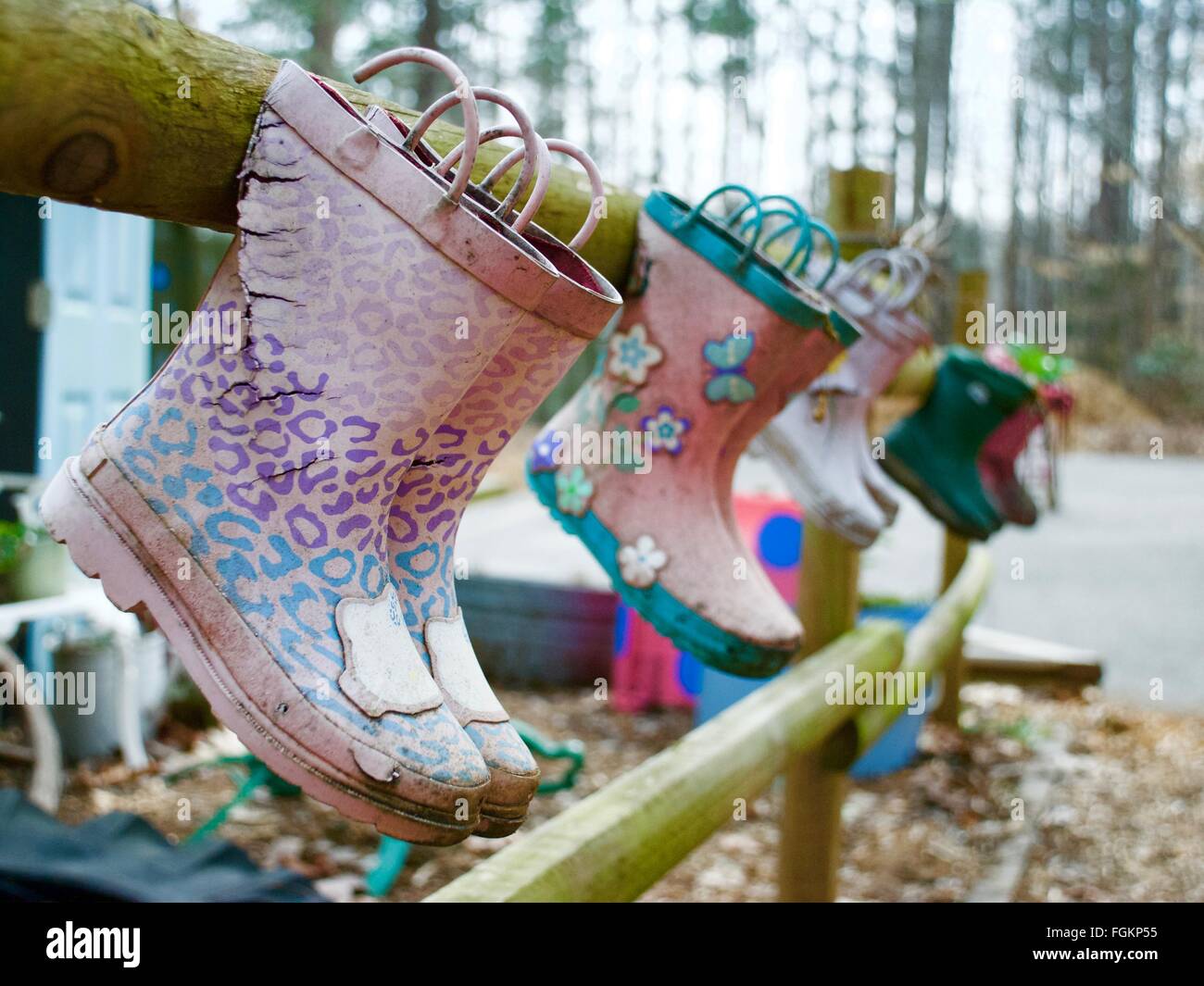 Boots hanging from fence to be flower pots when spring comes Stock Photo