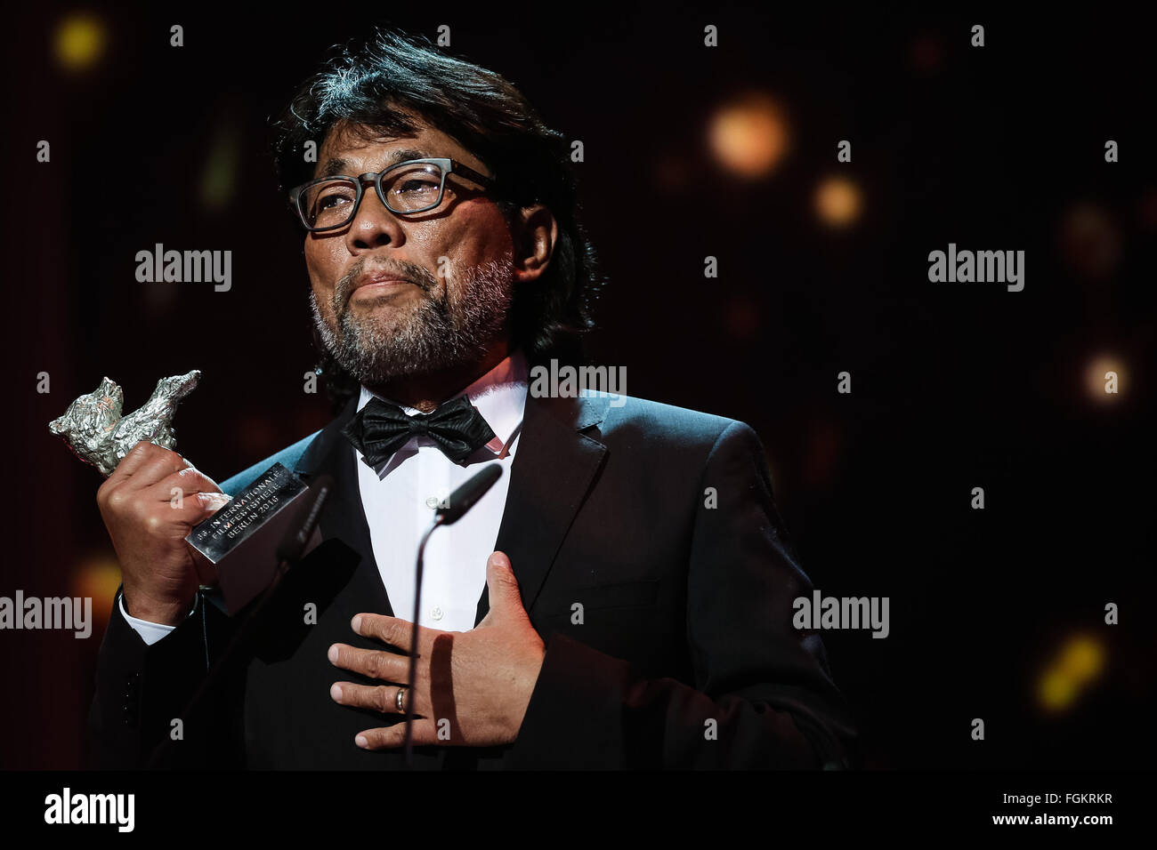 Berlin, Germany. 20th Feb, 2016. Mark Lee Ping-Bing, Cinematographer of the movie "Crosscurrent" (Chang Jiang Tu), holds the Silver Bear for Outstanding Artistic Contribution during the awards ceremony of the 66th Berlinale International Film Festival in Berlin, Germany, Feb. 20, 2016. © Zhang Fan/Xinhua/Alamy Live News Stock Photo