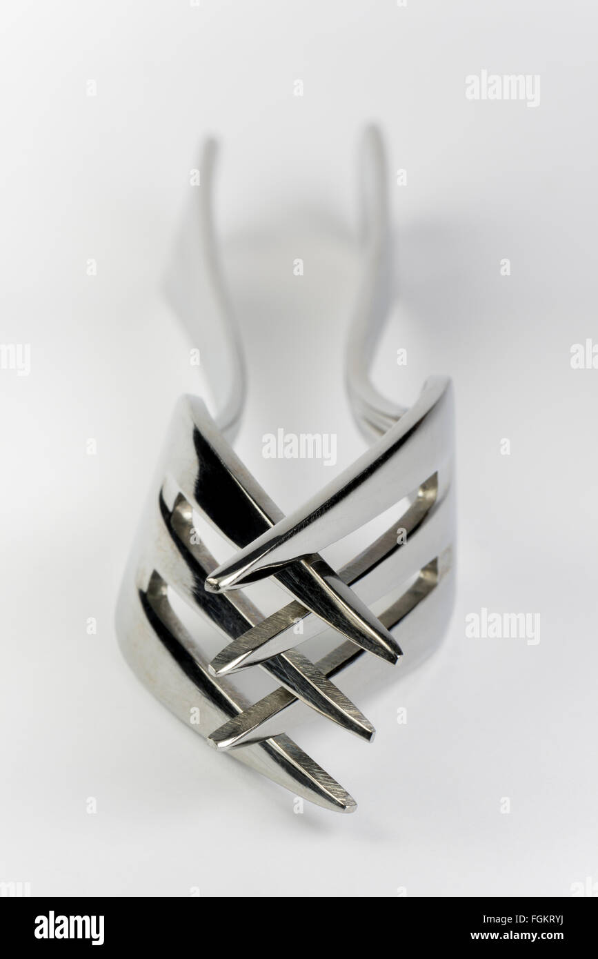 Abstract composition of two praying metal forks Stock Photo