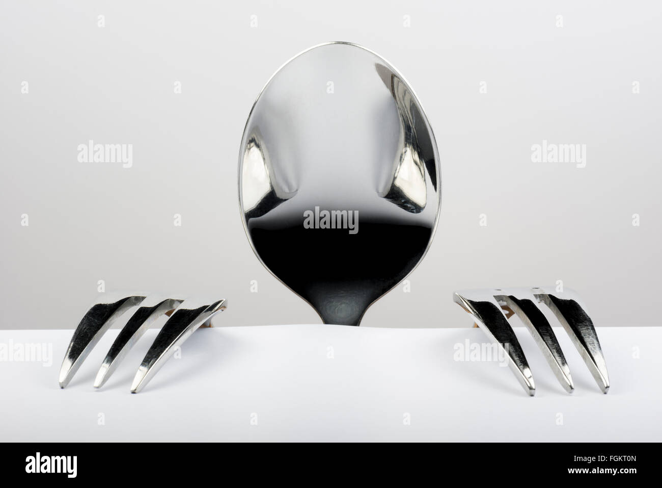 Spoon and two forks formed into conceptual figure Stock Photo Alamy