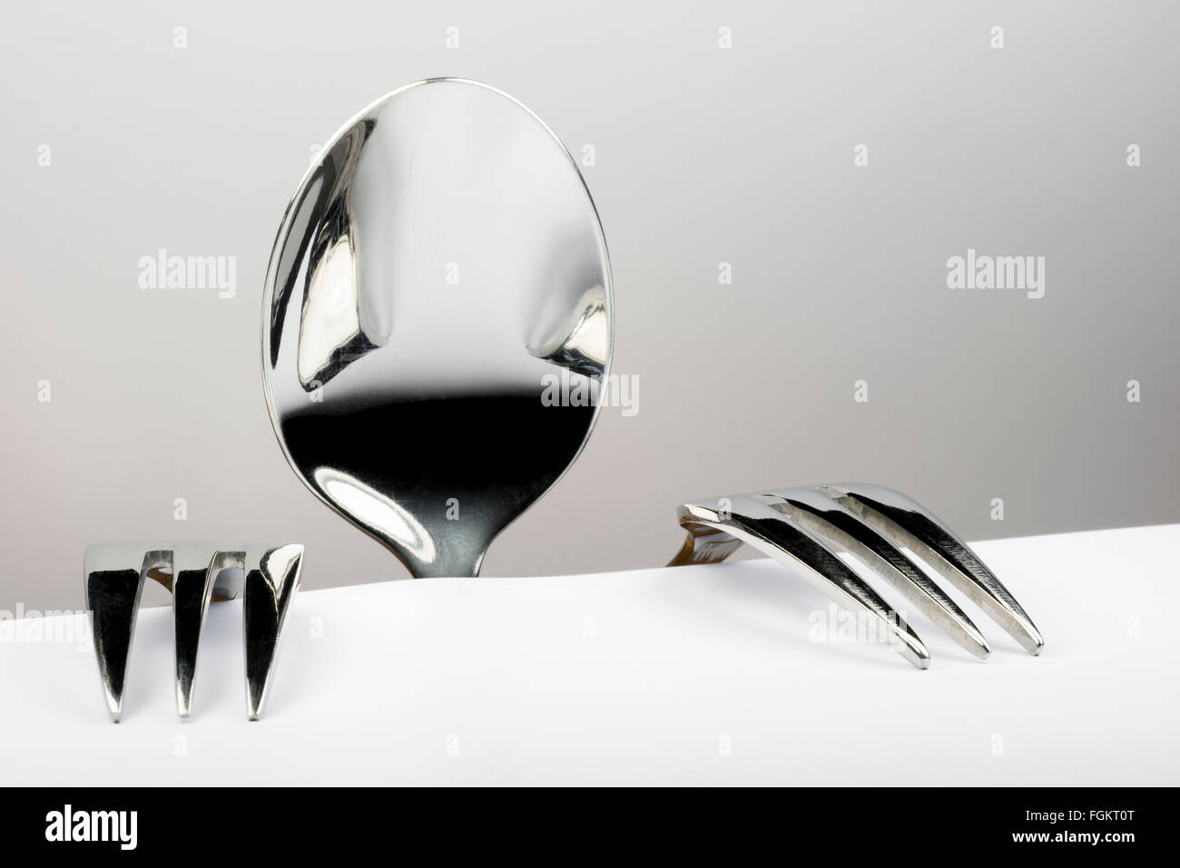 Spoon and two forks formed into conceptual figure Stock Photo Alamy