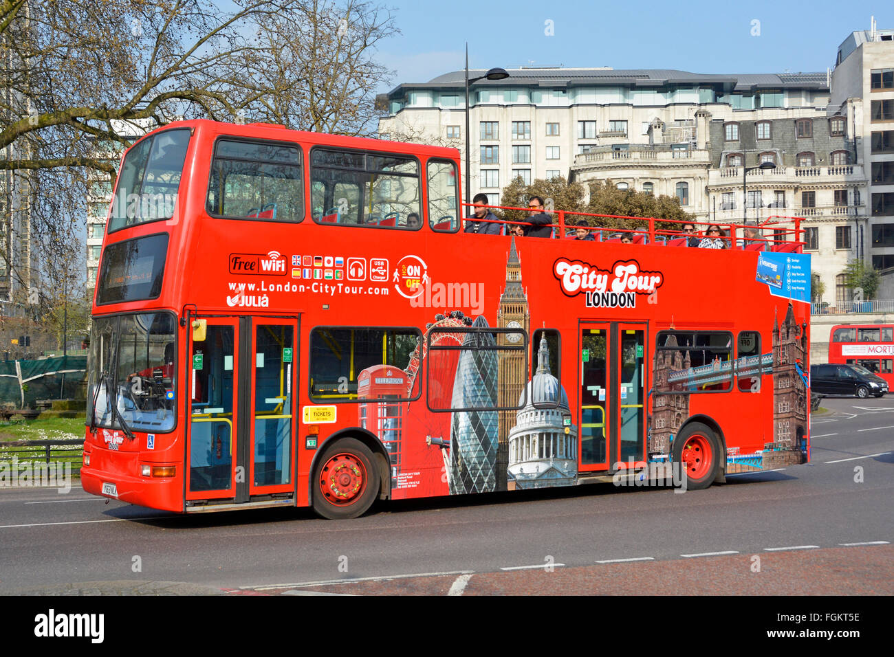 Open top tour bus double decker operated by City Tour providing a London sightseeing tourism trip seen here in Park Lane Mayfair UK Stock Photo