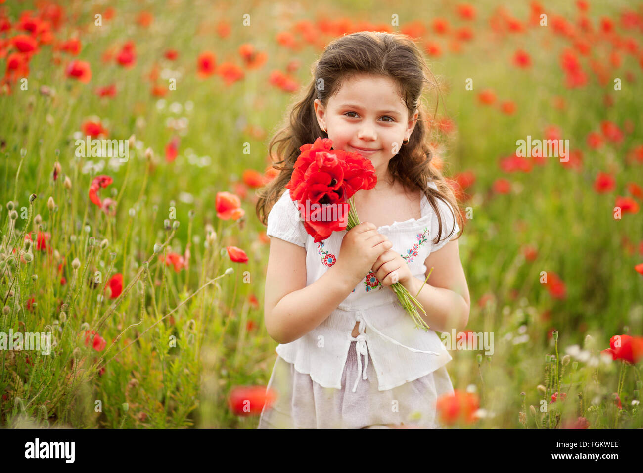 Happy kid with poppies. Stock Photo