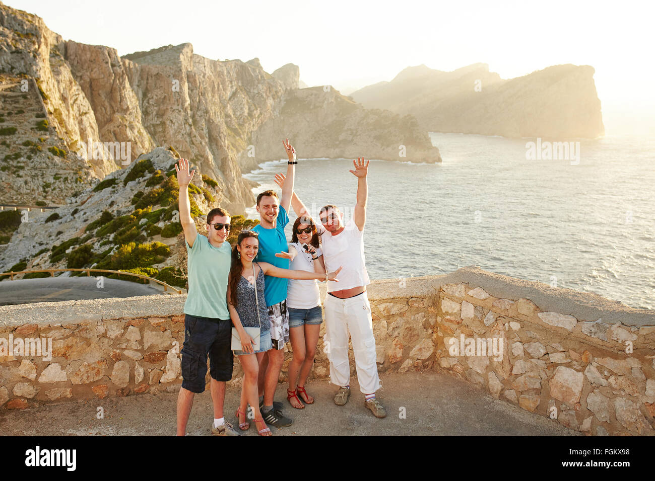 Group of happy people standing on sunset Stock Photo