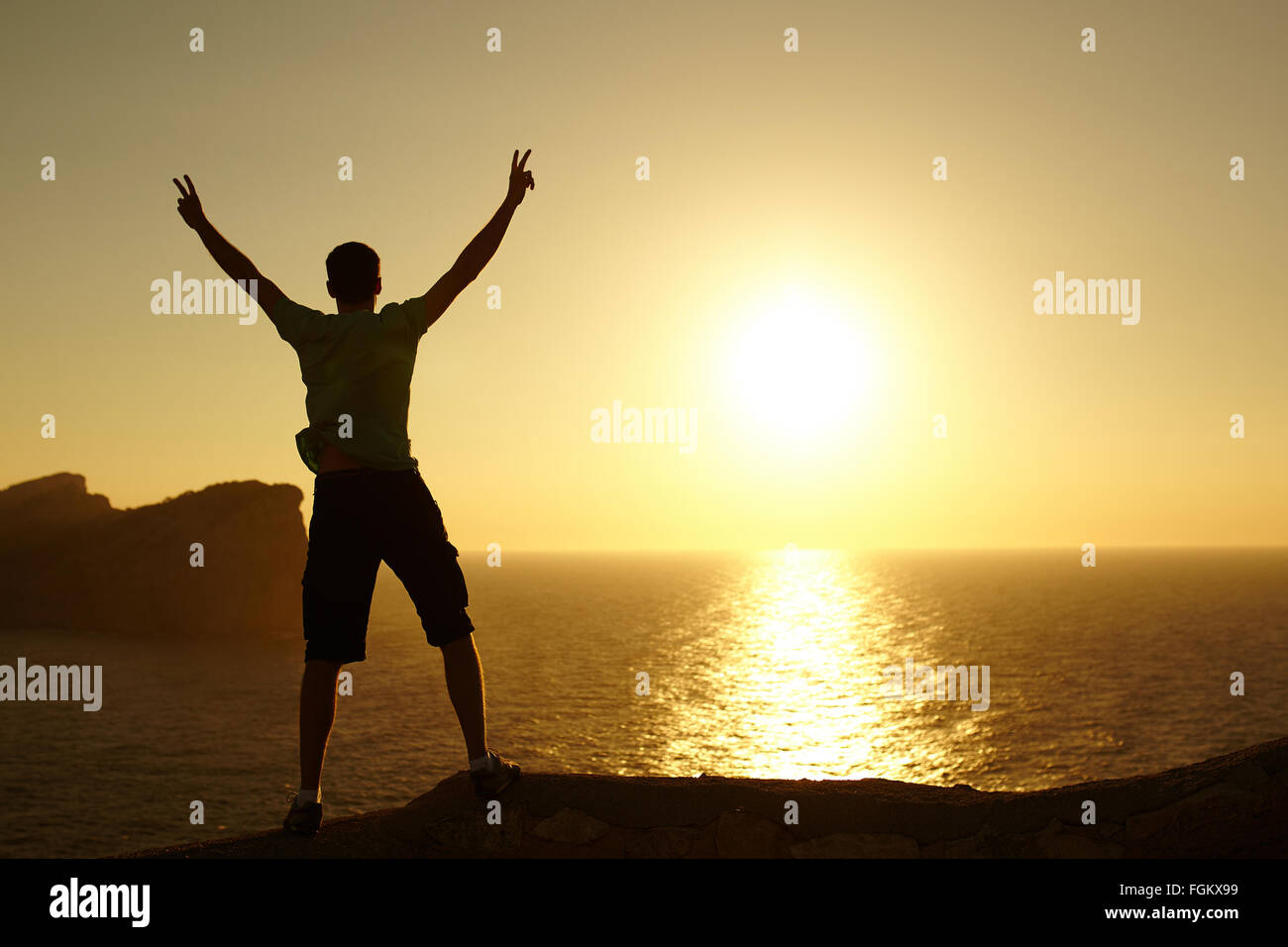 Silhouette of a man with raised arms Stock Photo