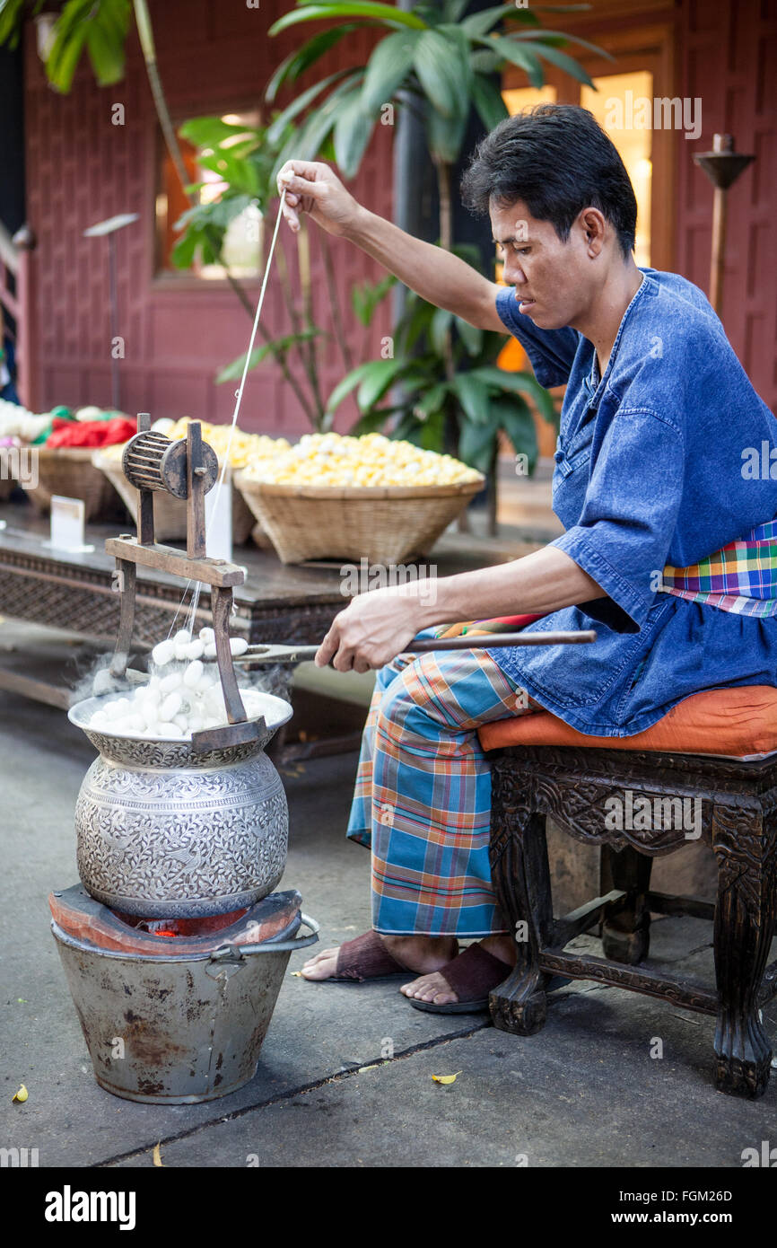 A man demonstrates how silk is made and extracts the silk thread from
