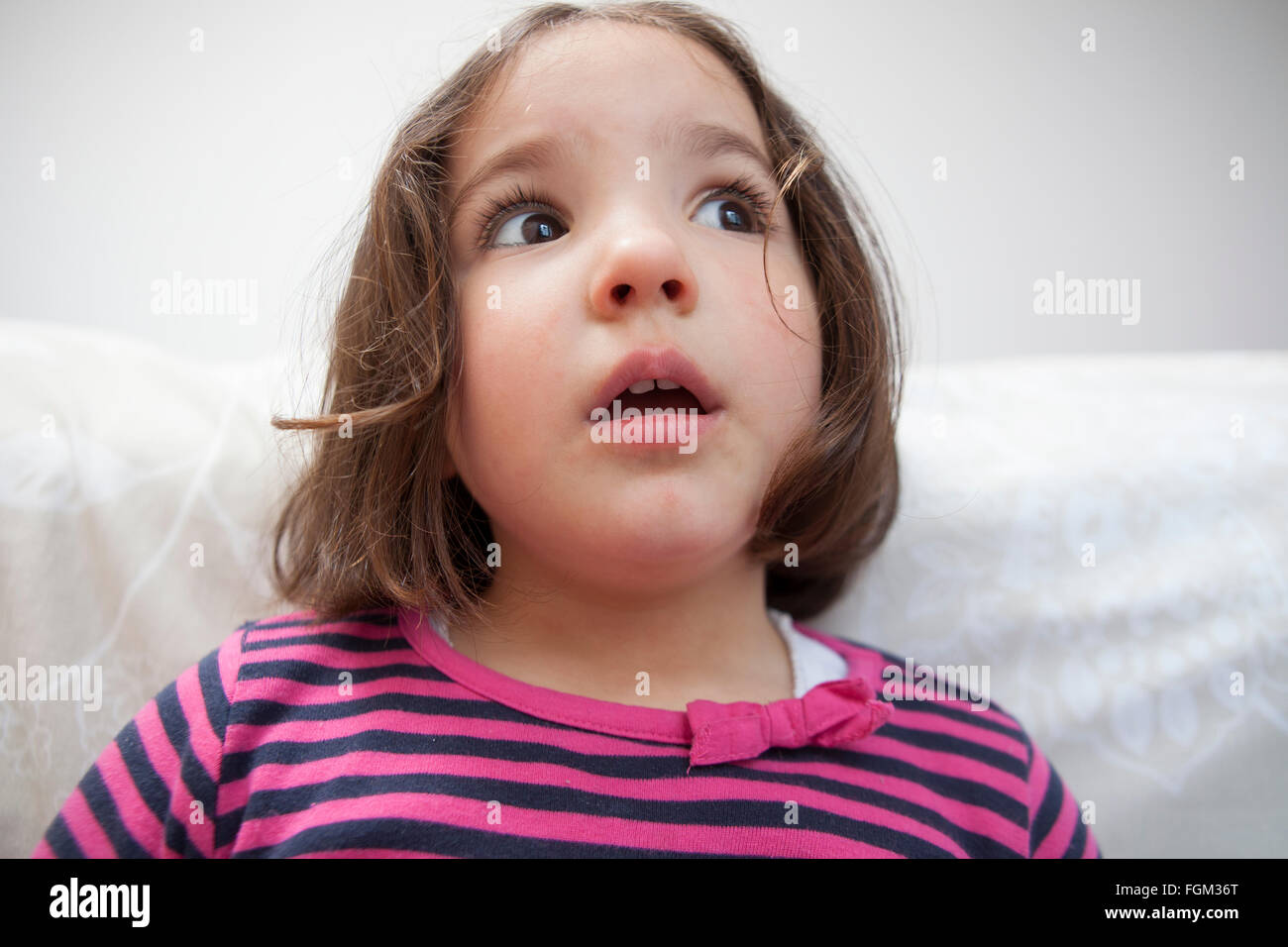 Astounded three years old  little girl. Indoors portrait Stock Photo